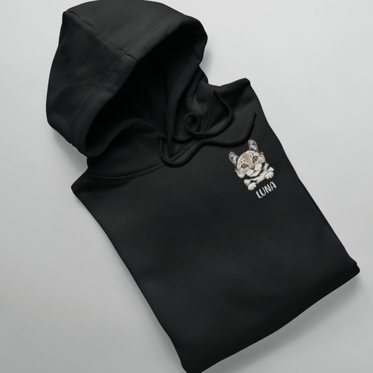 Folded hoodie displaying a peeking cat head design with a personalized name below.
