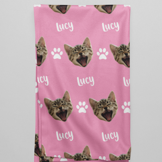 Folded blanket displaying a custom chosen cat head design and personalized name below it.