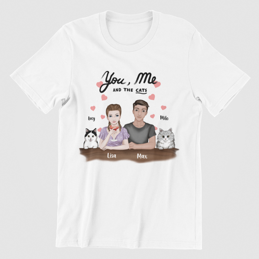 Unisex t-shirt displaying the 'You, Me AND THE CATS' design, featuring a personalized woman character, man character, and two chosen cat images, each labeled with a custom name.