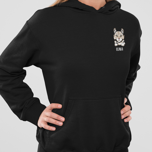 Woman wearing a hoodie featuring a peeking cat head design with a personalized name below.